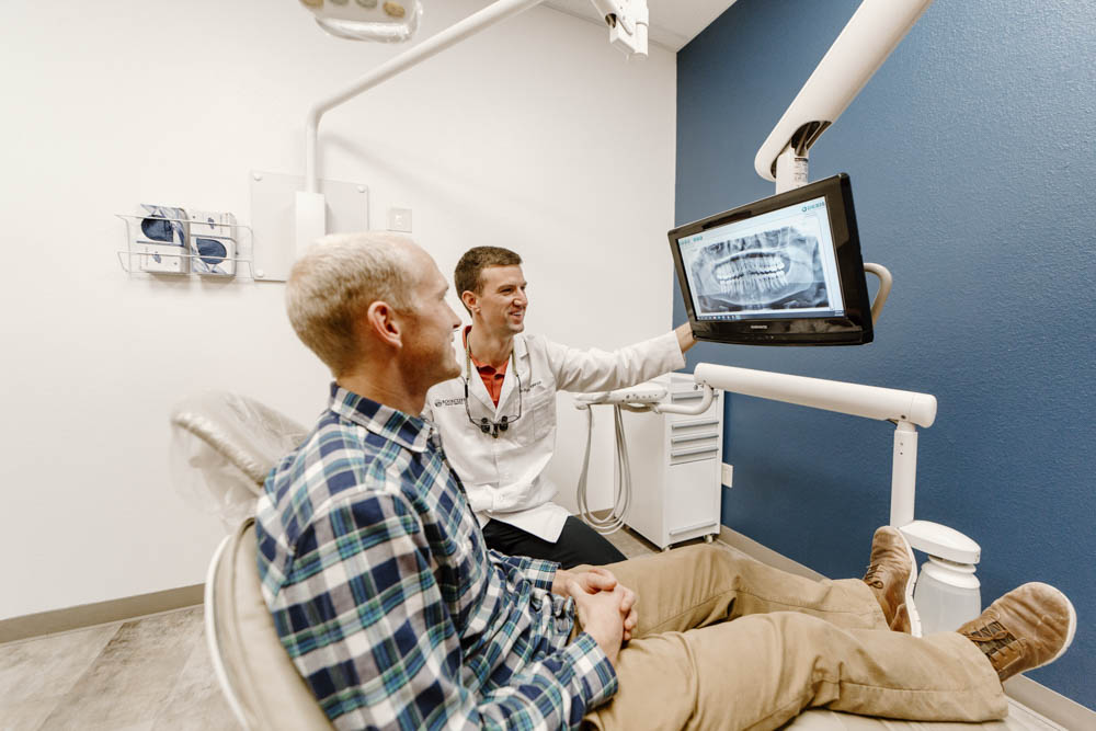 Dr. Ryan Helgerson showing x-rays to a patient