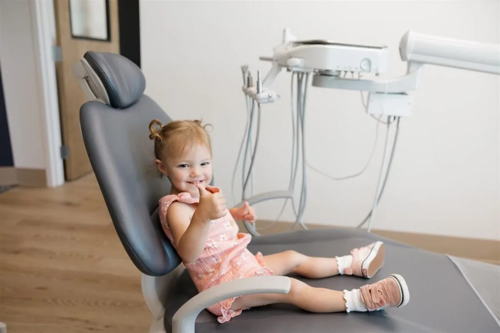 Young child in pink clothing seated comfortably in a gray dental chair at Bookcliff Family Dental in Grand Junction, CO, highlighting the clinic’s welcoming environment and gentle care approach for pediatric patients.