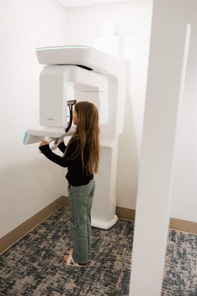 Patient positioned in front of a Vatech panoramic X-ray machine at Bookcliff Family Dental in Grand Junction, CO, showcasing the clinic’s advanced imaging technology and thorough approach to preventative dental diagnostics.